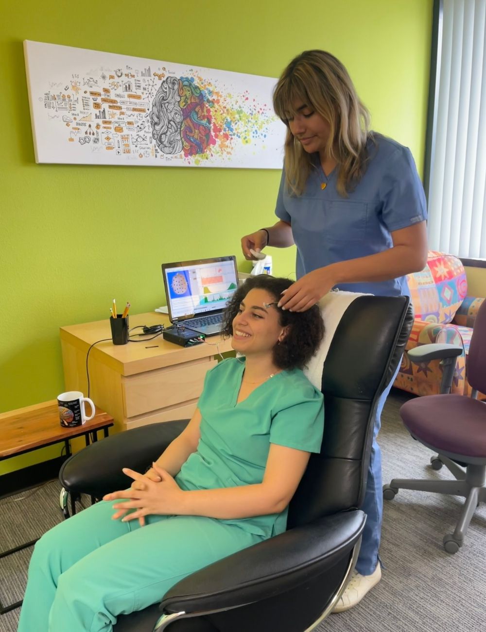Healthy Within technician placing a Direct Neurofeedback sensor on a smiling patient in San Diego